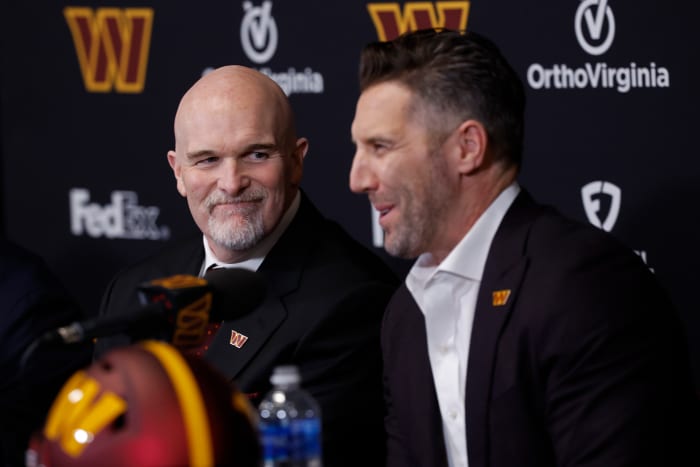 Washington Commanders head coach Dan Quinn (L) smiles as Commanders general manager Adam Peters (R) speaks during Quinn's introductory press conference at Commanders Park.